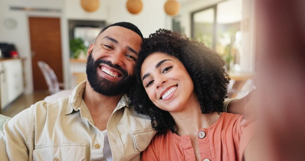Smiling couple taking a selfie at home